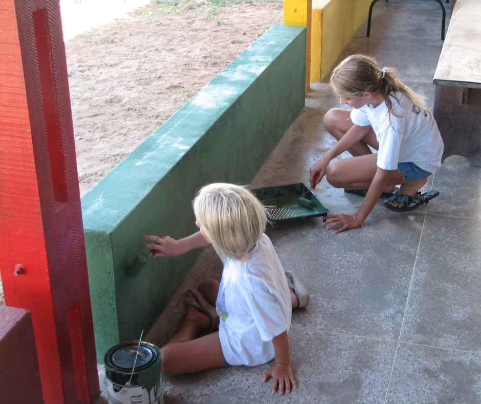 Two girls/volunteers painting walls at CBC