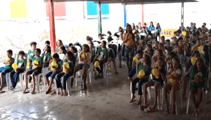 Teacher with students, balloon activity in assembly.