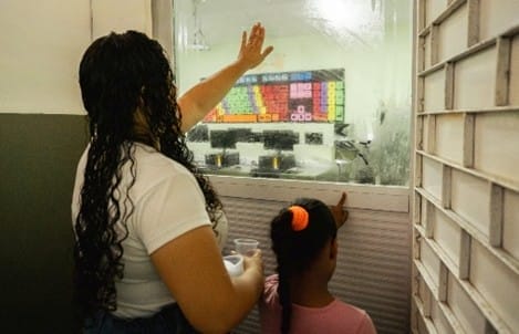 Child and teacher praying outside a classroom