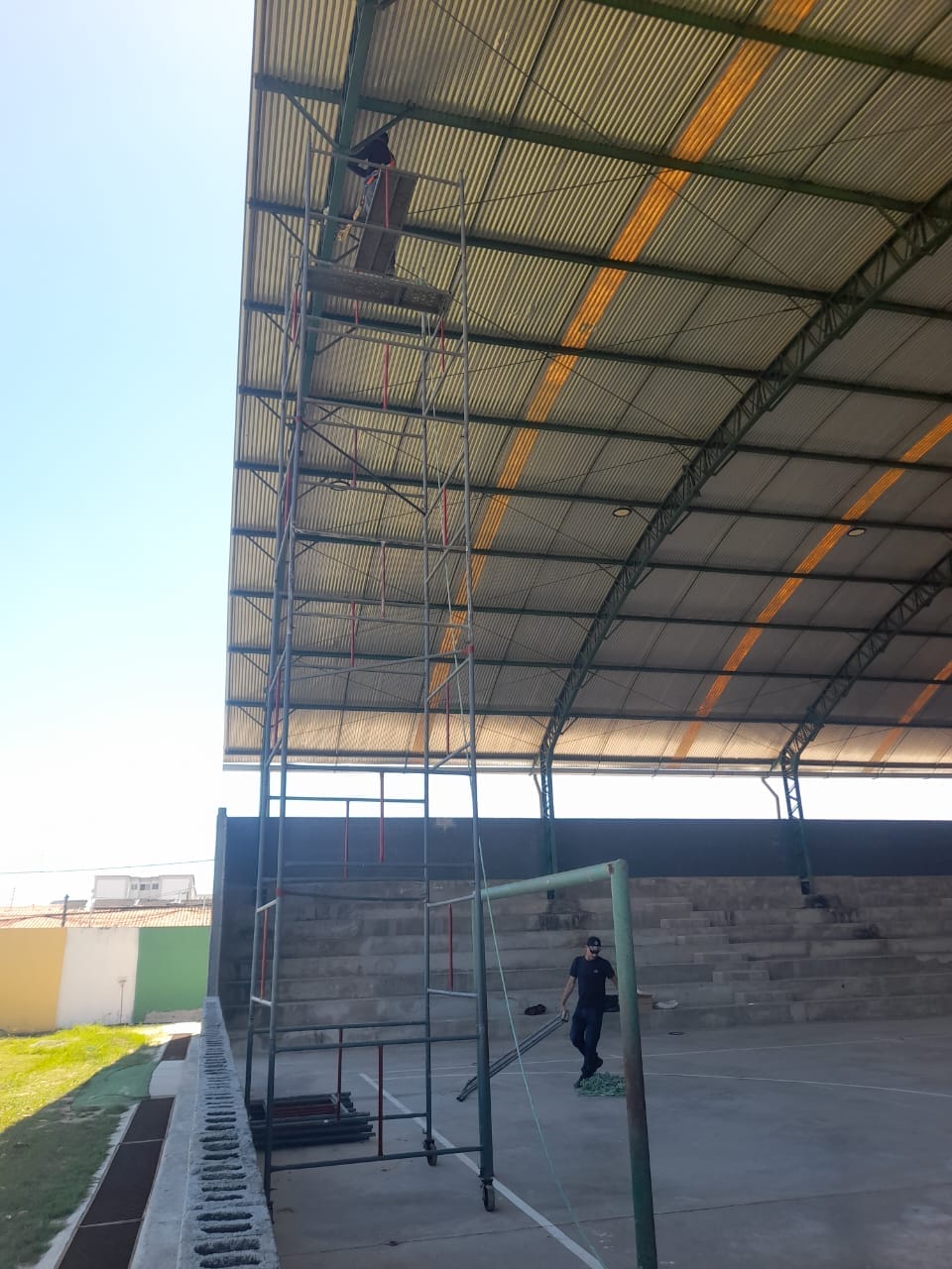 Man making repairs using Scaffolding under gymnasium